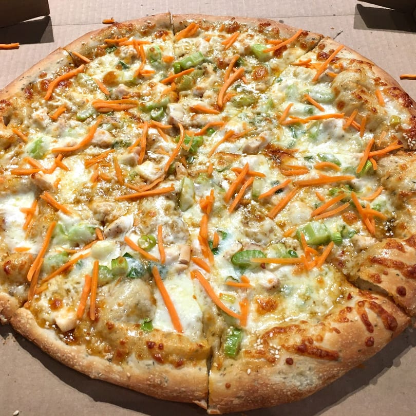 Lucy Blue Pizza's whole pizza with shredded carrots, green onions, chicken, and melted cheese.