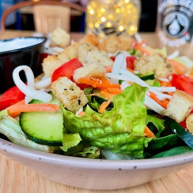 A fresh garden salad with lettuce, tomatoes, cucumbers, carrots, and croutons in a bowl.